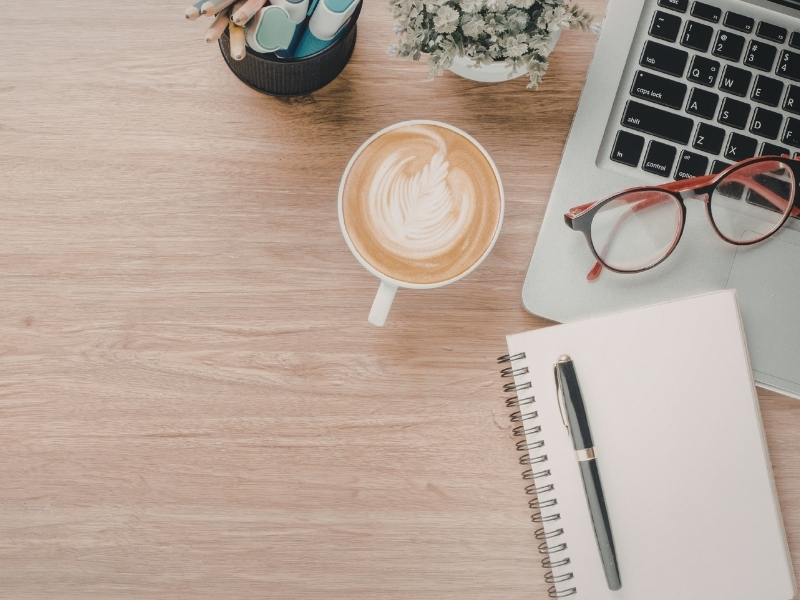 Warm tidy desk with notebook and mug